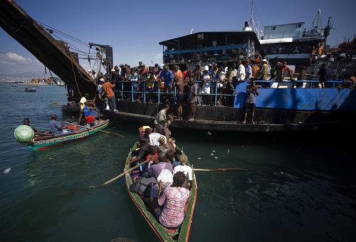 Local citizens try to flee this destroyed city by boat in Port-au-Prince, Haiti, Jan. 20, 2010. [David de la Pas/Xinhua]