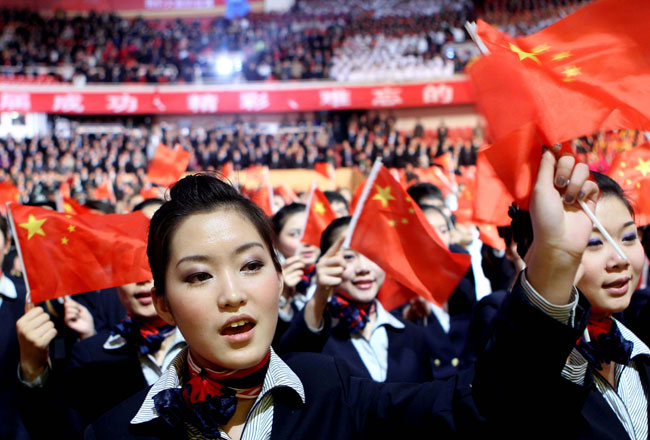 Participants wave China's national flags at a ceremony marking the 100-day countdown to 2010 Shanghai World Expo, Shanghai, January 21, 2010. [Xinhua]