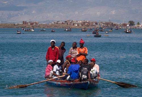 Local citizens try to flee this destroyed city by boat in Port-au-Prince, Haiti, Jan. 20, 2010. (Xinhua/David de la Pas)
