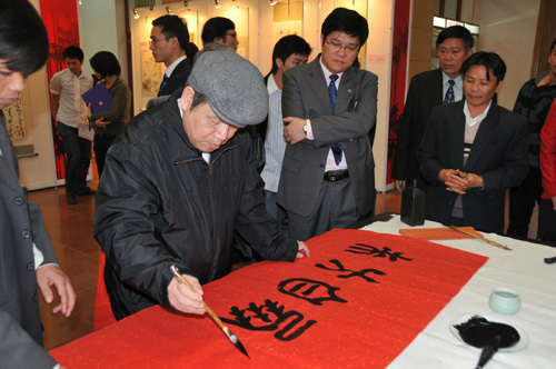 A calligrapher (2nd L) from Vietnam creates works in Vietnam-China Paintings and Calligraphy Exhibition in Hanoi, capital of Vietnam, January 21, 2010. 