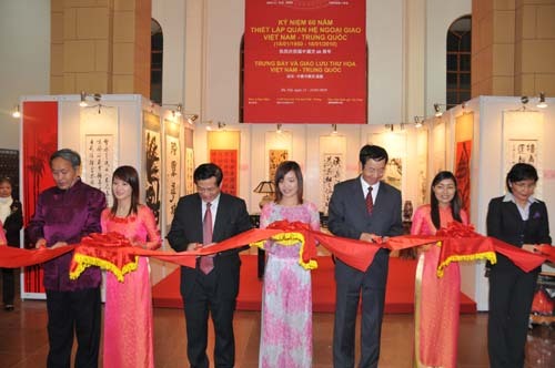 Deputy Minister of Culture, Sports and Tourism of Vietnam Tran Chien Thang (3rd Left in Front), Chinese Ambassador to Vietnam Sun Guoxiang (3rd Right in Front ) cut a ribbon for the opening of Vietnam-China Paintings and Calligraphy Exhibition in Hanoi, capital of Vietnam, January 21, 2010. [Xinhua photo]