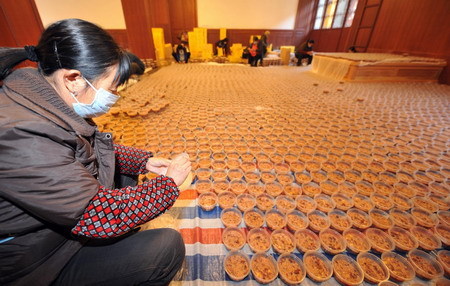Community volunteers pack Laba porridge at Lingyin Buddhist temple in Hangzhou, capital of east China's Zhejiang province January 19, 2010, in run-up to the traditional Laba Festival that befalls on the 8th day of the 12th lunar month. 