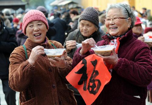 Elderly people drink Laba porridge at Bilu Temple in Nanjing, capital of east China's Jiangsu Province, Jan. 22, 2010. The tradition of drinking the porridge, cooked with fresh paddy rice, dried fruits and nuts on the Laba Festival, is observed throughout China every year. Laba Festival falls on Jan. 22 this year. (Xinhua/Sun Can)