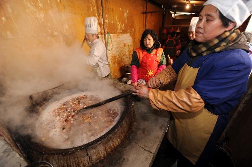 Staff members cook Laba porridge to be served free of charge at Bilu Temple in Nanjing, capital of east China's Jiangsu Province, Jan. 22, 2010. (Xinhua/Sun Can)