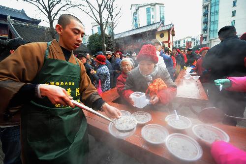 A monk offers 'Laba Porridge' to people at Bilu Temple in Nanjing, capital of east China's Jiangsu Province, Jan. 22, 2010.(Xinhua/ Sun Can)