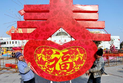Handicraftsmen carry a giant lantern at Dongfang Square in Rushan city, east China's Shandong Province, Jan. 22, 2010. Over 100 local handicraftsmen in Rushan were busy preparing for the upcoming spring lantern fair to greet the Chinese lunar New Year. 