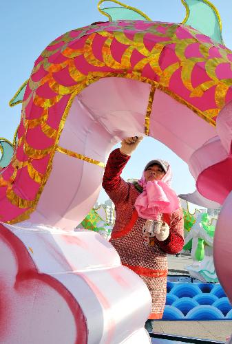 A handicraftsman gives final touch to a dragon lantern at Dongfang Square in Rushan city, east China's Shandong Province, Jan. 22, 2010. Over 100 local handicraftsmen in Rushan were busy preparing for the upcoming spring lantern fair to greet the Chinese lunar New Year. 