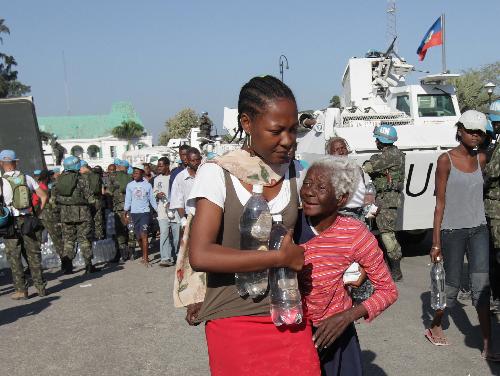 Residents get bottled water at an aid distribution site in Port-au-Prince, capital of Haiti, on Jan. 22, 2010, ten days after a catastrophic earthquake hit the nation on Jan. 12. 