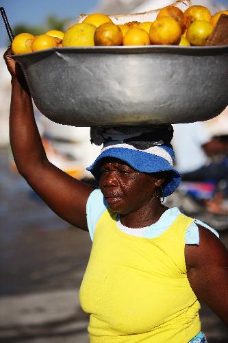 A woman heads up some fruits in a street in Port-au-Prince, capital of Haiti, on Jan. 22, 2010, ten days after a catastrophic earthquake hit the nation on Jan. 12. 