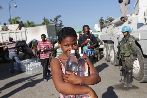 A girl receives bottled water at an aid distribution site in Port-au-Prince, capital of Haiti, on Jan. 22, 2010, ten days after a catastrophic earthquake hit the nation on Jan. 12. 