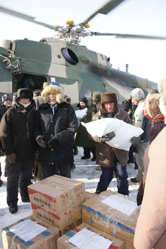 A helicopter delivers relief goods for local residents in northwest China's Xinjiang Uygur Autonomous Region, Jan. 23, 2010. Two Chinese military helicopters on Saturday delivered 10 rescuers to Altay in blizzard-hit Xinjiang to search for the missing people. The 14 people trapped in blizzard-hit areas of Xinjiang had been rescued by the military and sent to hospital for treatment. 