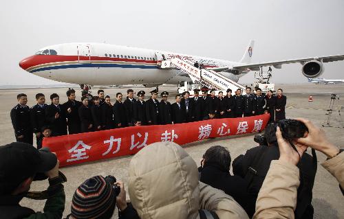 Crew members of China Eastern Airlines' liner A340 pose in front of the plane at Shanghai Hongqiao Airport Jan. 23, 2010. The plane will carry another 77-member medical and epidemic prevention team and more than 20 tons of relief materials to Haiti on Sunday.