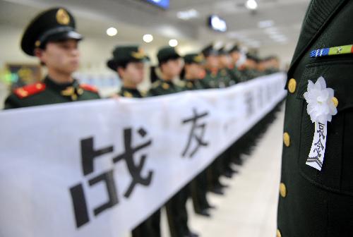 Border defence soldiers hold banners to bid farewell to Zhong Jianqin, a Chinese peacekeeping police officer who were killed in the 7.3-magnitude earthquake in Haiti, at the Changbei airport in Nanchang, capital of east China's Jiangxi Province, Jan. 23, 2010. Zhong's bone ash was returned to his hometown in Nanfeng county on Saturday.