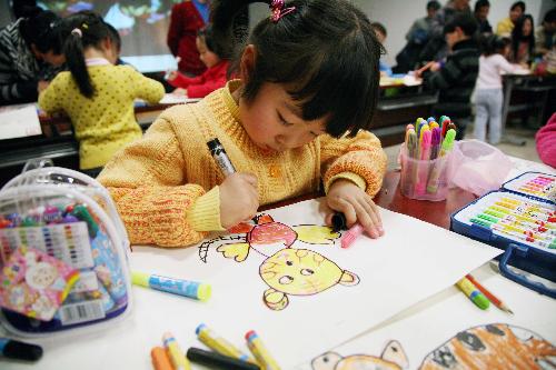 A little girl is engrossed in drawing cartoon painting of tiger in Nanjing, east China's Jiangsu Province, Jan. 23, 2010. Some 100 children of 4 to 14 years old gathered here Saturday, to draw the vivid images of tiger as the Year of Tiger in traditional Chinese lunar calendar approaching.