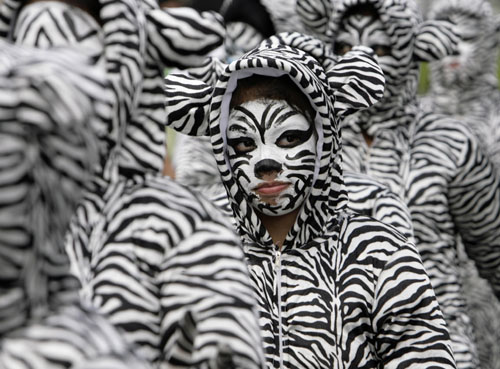 Students wear costumes inspired by nature at a parade during &apos;Caracol 2010&apos;, a local version of Mardi Gras, along Makati, the financial district of Manila January 24, 2010. Caracol is part of the city government&apos;s commitment to conserve the environment and natural resources. [Xinhua/Reuters]