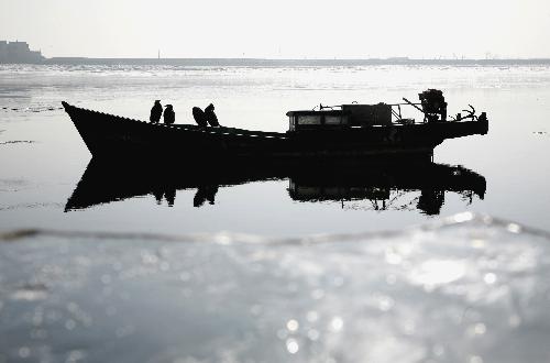 Photo taken on Jan. 23, 2010 shows a ice-bound fishing boat at the Yalu River, in Dandong City, northeast China's Liaoning Province. Local section of the Yalu River was frozen due to continued cold wave that gripped the city recently. (Xinhua/Qi Wanpeng)