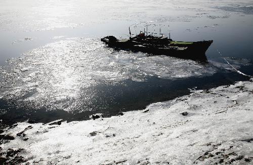 Photo taken on Jan. 23, 2010 shows a ice-bound fishing boat at the Yalu River, in Dandong City, northeast China's Liaoning Province. Local section of the Yalu River was frozen due to continued cold wave that gripped the city recently. (Xinhua/Qi Wanpeng)