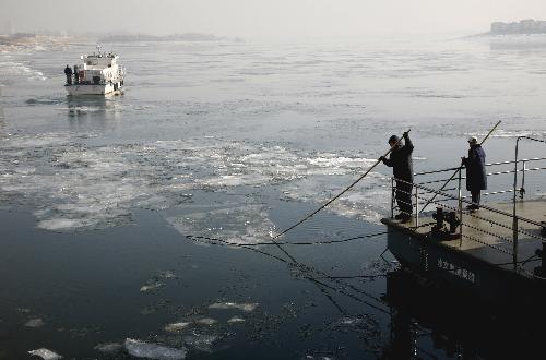 Workers break the ice at the Yalu River in Dandong City, northeast China's Liaoning Province, Jan. 23, 2010. Local section of the Yalu River was frozen due to continued cold wave that gripped the city recently. (Xinhua/Qi Wanpeng)