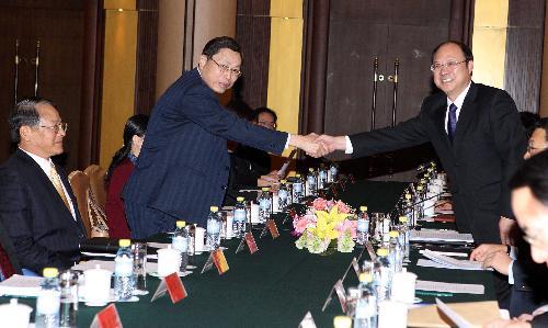 Zheng Lizhong (R), executive vice president of the Chinese mainland's Association for Relations Across the Taiwan Straits (ARATS), shakes hands with Kao Kung-lian, vice chairman and secretary general of Taiwan's Straits Exchange Foundation (SEF), during the first expert discussion in talks on the Economic Cooperation Framework Agreement (ECFA), an economic deal which is expected to boost the cross-Taiwan Straits economic ties, in Beijing, capital of China, Jan. 26, 2010. (Xinhua