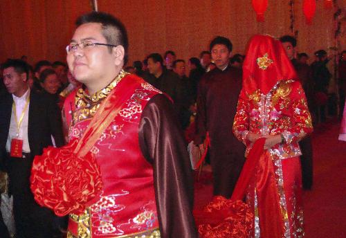 Bridegroom Li Zhaohui leads his bride Che Xiao with a long red silk belt into the nuptial in traditional Chinese red wedding gown, during their marriage ceremony in traditional Chinese style, in Wenxi County, Shanxi Province, Jan. 25, 2010.