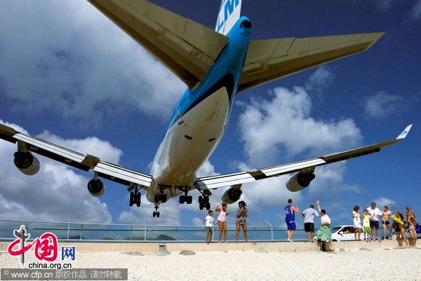 Tourists are flocking to a beach directly under the flight path of jumbo jets to feel the impressive force of their jet stream as they pass just 20 metres over head. 