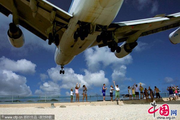 Tourists are flocking to a beach directly under the flight path of jumbo jets to feel the impressive force of their jet stream as they pass just 20 metres over head. 