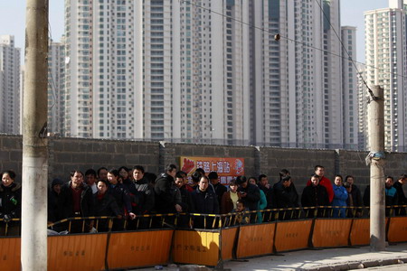 Passengers queue to buy train tickets to go home outside the Shanghai Railway Station January 26, 2010. [China Daily via Agencies]