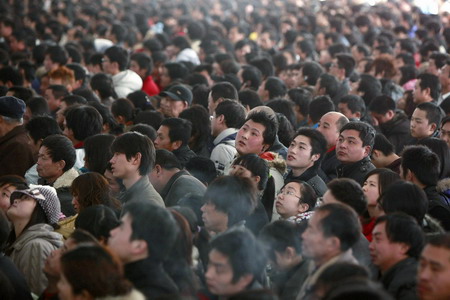 Passengers read information on an electronic screen for train tickets at the Shanghai Railway Station January 26, 2010.[China Daily via Agencies]