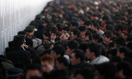 Passengers queue to buy train tickets to go home at the Shanghai Railway Station January 26, 2010.[China Daily via Agencies] 