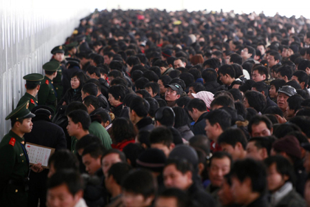 Passengers queue to buy train tickets to go home at the Shanghai Railway Station January 26, 2010. [China Daily via Agencies]