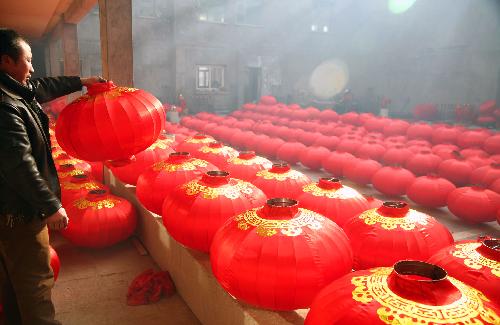 A local farmer airs newly-made red lanterns at a big yard in Hongmiao Village in Huairou District in Beijing, the capital of China, Jan. 26, 2010. The mountain village enjoyed a long history for producing Chinese traditional red lanterns in winter to meet the large demand from the festival market as the Spring Festical, the Chinese lunar new year, approaching. [Xinhua]