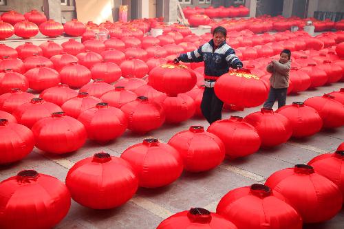 Local farmers air newly-made red lanterns at a big yard in Hongmiao Village in Huairou District in Beijing, the capital of China, Jan. 26, 2010. The mountain village enjoyed a long history for producing Chinese traditional red lanterns in winter to meet the large demand from the festival market as the Spring Festical, the Chinese lunar new year, approaching. [Xinhua]