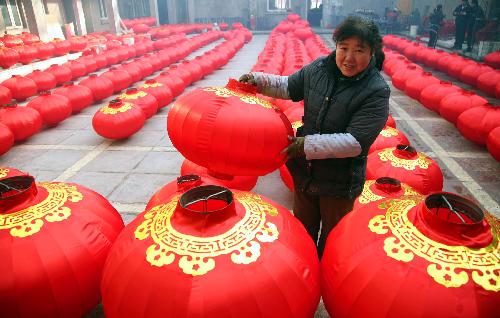 A local farmer airs newly-made red lanterns at a big yard in Hongmiao Village in Huairou District in Beijing, the capital of China, Jan. 26, 2010. The mountain village enjoyed a long history for producing Chinese traditional red lanterns in winter to meet the large demand from the festival market as the Spring Festical, the Chinese lunar new year, approaching. [Xinhua]