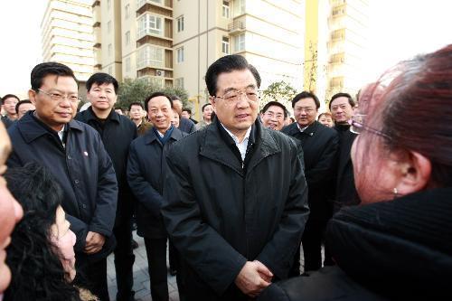 Chinese President Hu Jintao (C Front) talks with local residents during visit to high-rise residential buildings, which used to be a shanty community in Beilin District in Xi'an, northwest China's Shaanxi Province, Jan. 25, 2010. Hu concluded a three-day tour to the quake-hit Shaanxi Province on Tuesday, calling for more efforts to beef up reconstruction with high quality. 