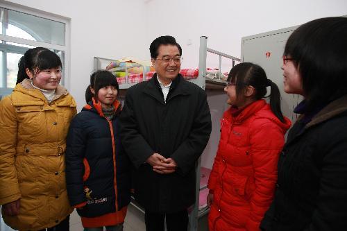 Chinese President Hu Jintao (C) talks with students during his inspection at a school in Ningqiang County in Hanzhong City, northwest China's Shaanxi Province, Jan. 24, 2010. 