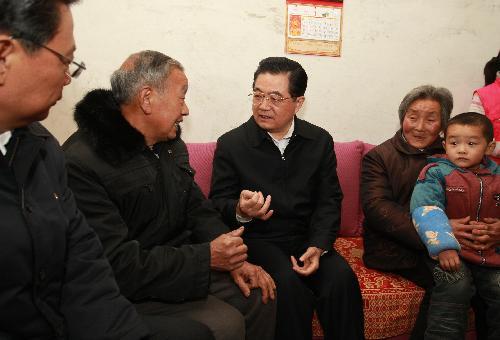 Chinese President Hu Jintao (C) talks with local residents relocated after the earthquake in 2008 during his inspection in Ningqiang County in Hanzhong City, northwest China's Shaanxi Province. 