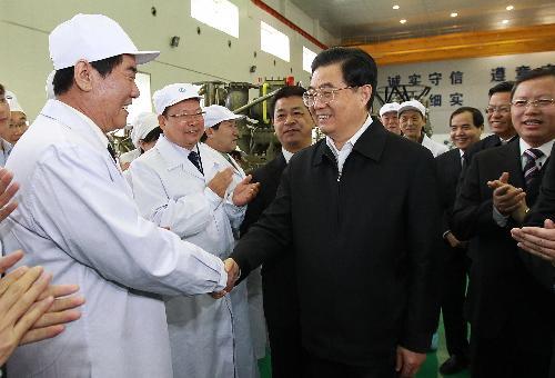 Chinese President Hu Jintao (C Front) shakes hands with researchers during his inspection at an aerospace research institute in northwest China's Shaanxi Province. 