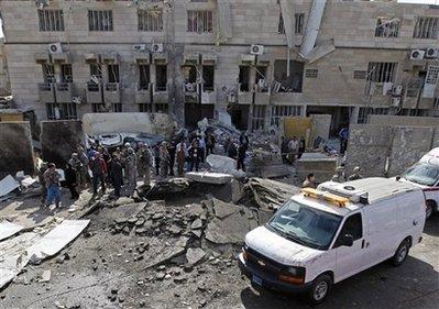 People gather at the site of a car bomb attack in central Baghdad, Iraq, Tuesday, Jan. 26, 2010. 