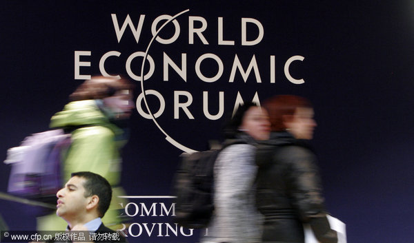 People walk by a sign in the congress center at a meeting of the World Economic Forum in Davos, Switerzland Monday Jan. 25, 2010.Ffinancial reforms, climate talks and haiti's reconstruction are set to dominate the agenda of the world's elites heading up to the Swiss mountain resort of davos this week for their annual meeting. [CFP]