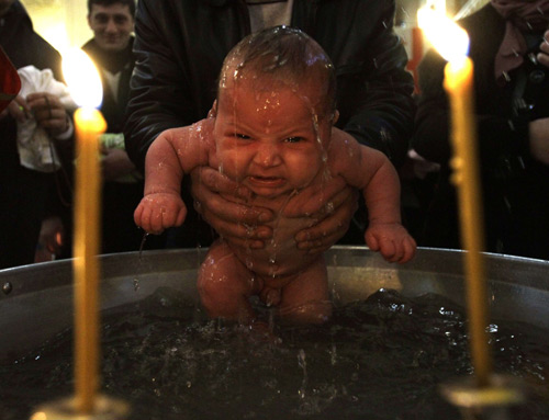 A baby is baptised during a mass baptism ceremony in Tbilisi, January 27, 2010. About 500 children were baptised by the Georgian Orthodox church during a mass baptism ceremony at the country&apos;s main cathedral Holy Trinity. [Xinhua/Reuters]