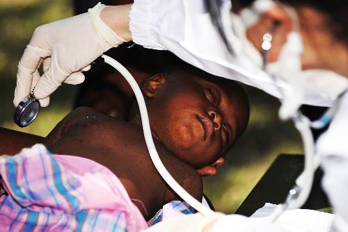 A Haitian child receives medical treatment at a makeshift hospital set up by a Chinese medical team in Port-au-Prince Jan. 27, 2010. The team will stay in Haiti for weeks to provide basic medical care for survivors of the Jan. 12 earthquake. [Xinhua] 
