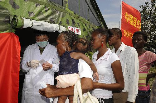 Haitians wait to receive medicine at a makeshift hospital set up by a Chinese medical team in Port-au-Prince Jan. 27, 2010. The team will stay in Haiti for weeks to provide basic medical care for survivors of the Jan. 12 earthquake. [Xinhua]
