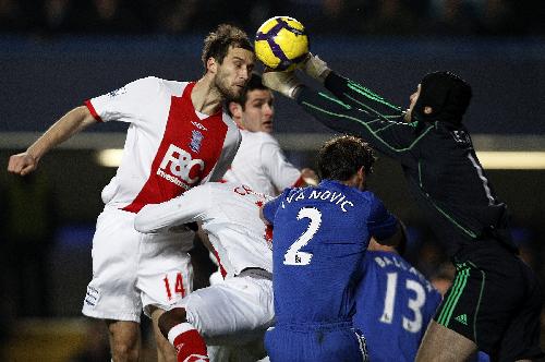 Chelsea's goalkeeper Petr Cech (R) challenges Birmingham City's Roger Johnson during their English Premier League soccer match at Stamford Bridge in London January 27, 2010.(Xinhua/Reuters Photo)