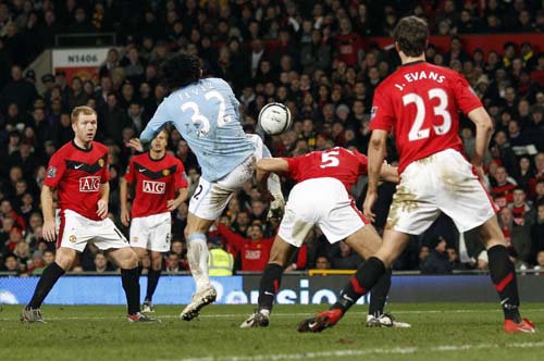 Manchester City's Carlos Tevez (C) shoots to score against Manchester United during their English League Cup soccer match in Manchester, northern England January 27, 2010.