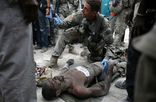 Rico Dibrivell, 35, is attended by a U.S. military rescue team member after being freed from the rubble of a building in Port-au-Prince January 26, 2010. [Xinhua] 