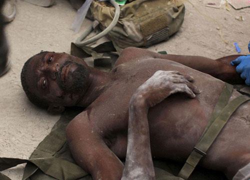 Rico Dibrivell, 35, is attended by a U.S. military rescue team member after being freed from the rubble of a building in Port-au-Prince January 26, 2010. [Xinhua] 