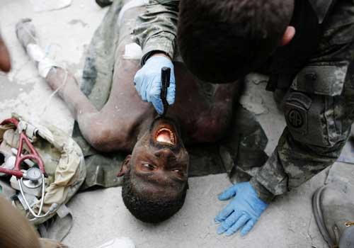 Rico Dibrivell, 35, is attended by a U.S. military rescue team member after being freed from the rubble of a building in Port-au-Prince January 26, 2010. [Xinhua] 
