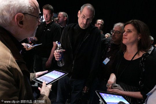 Apple Inc. CEO Steve Jobs (C) talks with Technology Columnist Walt Mossberg (L) of the Wall Street Journal during an Apple Special Event at Yerba Buena Center for the Arts January 27, 2010 in San Francisco, California. CEO Steve Jobs and Apple Inc. introduced its latest creation, the iPad, a mobile tablet browsing device that is a cross between the iPhone and a MacBook laptop. [CFP]