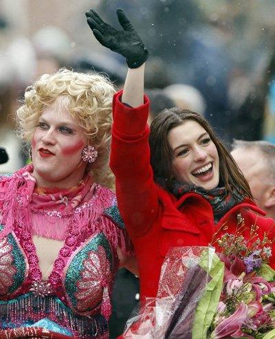 Actress Anne Hathaway waves next to Hasty Pudding Theatricals President Clifford Murray, dressed in drag, during the parade to honor her as Hasty Pudding Theatricals Woman of the Year at Harvard University in Cambridge, Massachusetts January 28, 2010.[CRI/Agencies]