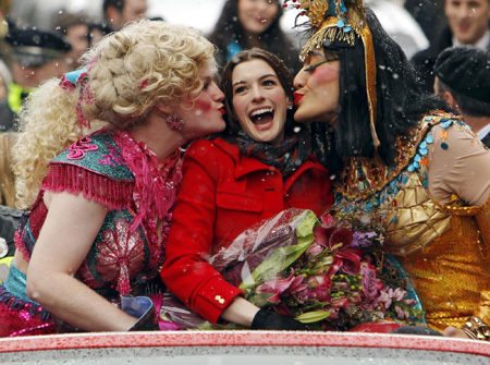 Actress Anne Hathaway (C) gets a kiss from Hasty Pudding Theatricals President Clifford Murray (L) and Vice President of the cast Derek Mueller, both dressed in drag, during the parade to honor her as Hasty Pudding Theatricals Woman of the Year at Harvard University in Cambridge, Massachusetts January 28, 2010.[CRI/Agencies] 
